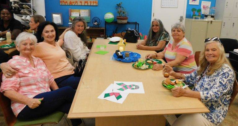 Senior Women sit around a table at NAMI Collier